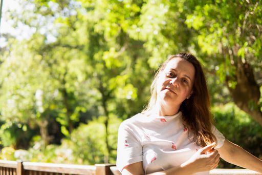 A portrait of a beautiful brunette Spanish woman posing outside in nature on a sunny day