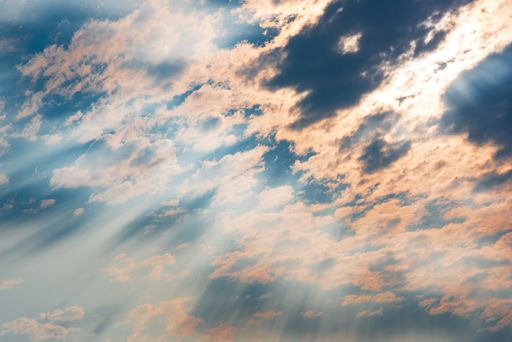 A beautiful cloudscape with pink rays of the sun penetrating