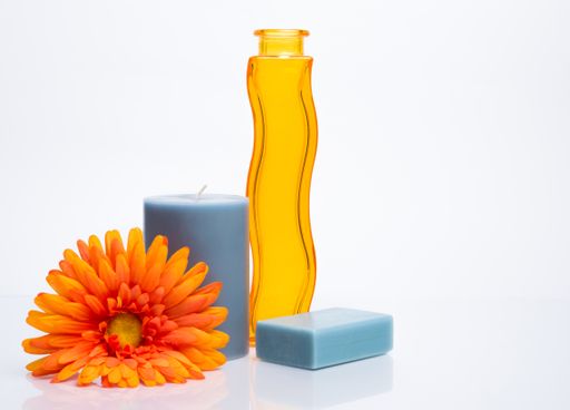 A closeup shot of a decorative yellow vase and candles with a flower on an isolated background