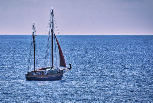 A beautiful shot of a sailing boat travels across the ocean