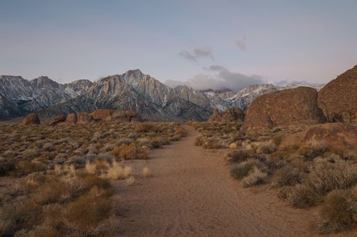 A hiking trail travels through the Alabama Hills area in eastern California in the direction of Mt Whitney and the Sierra Nevada mountain range.