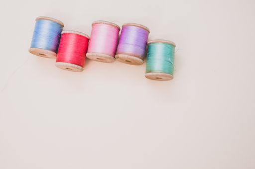 A colorful sewing threads on a light background with free space for text