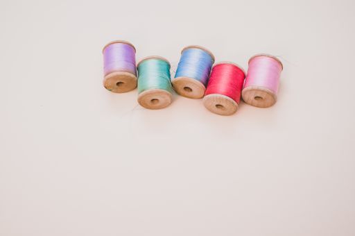 A colorful sewing threads on a light background with free space for text