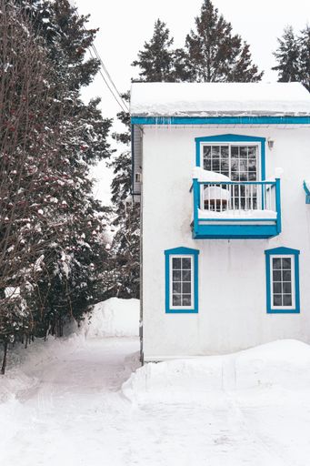 A vertical shot of a house covered with white snow during winter