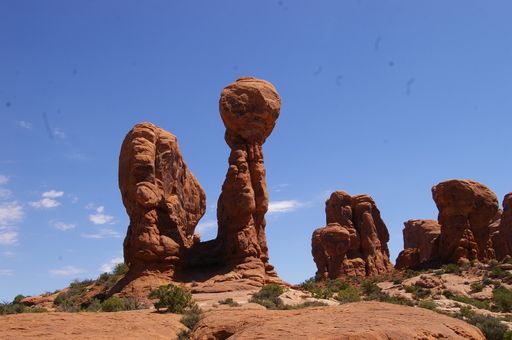 A red rocky outcrop beside a parched desert landscape in Utah