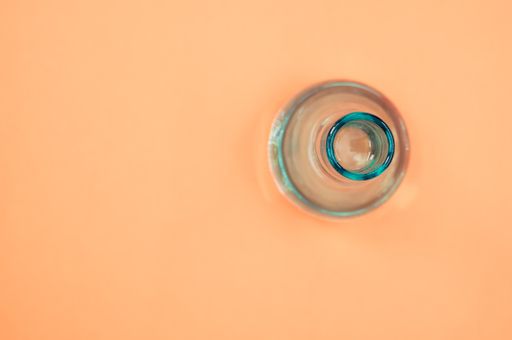 A crystal flower vase isolated on a pastel orange background with free space for text