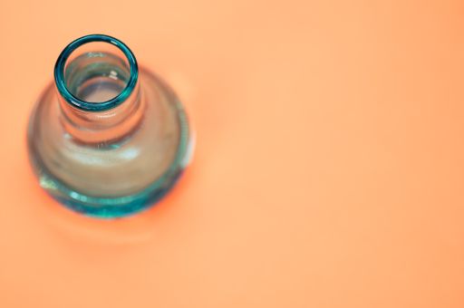 A crystal flower vase isolated on a pastel orange background with free space for text