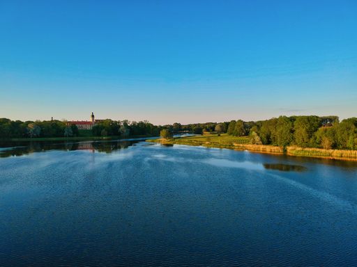 An aerial shot of a lake surrounded by fields and village