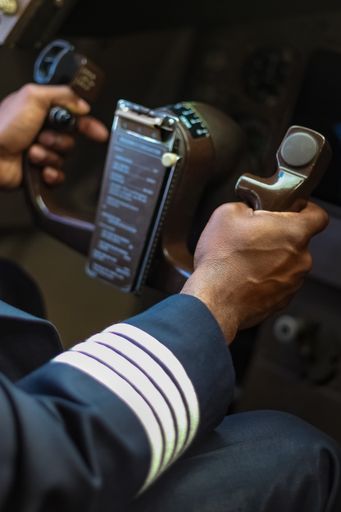 A closeup shot of male hands holding an aircraft steering wheel
