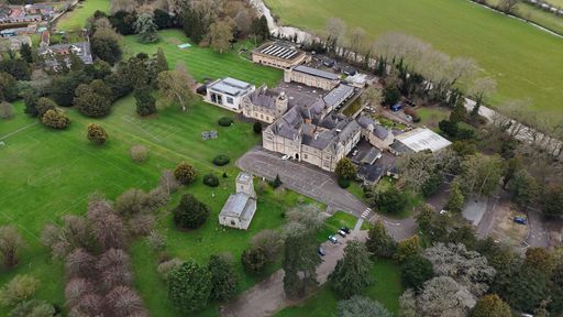 Aerial view of a house surrounded by lush green grass