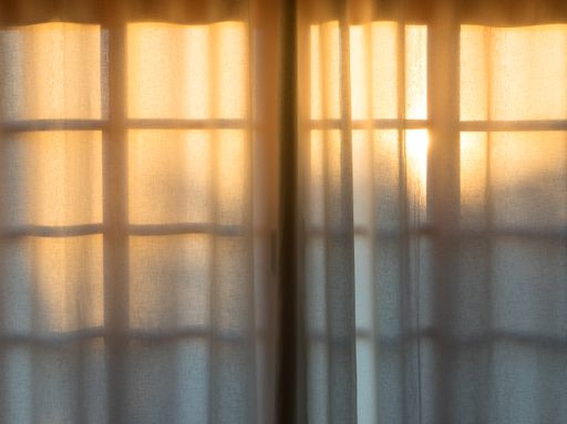 The sunset behind a window with a curtain