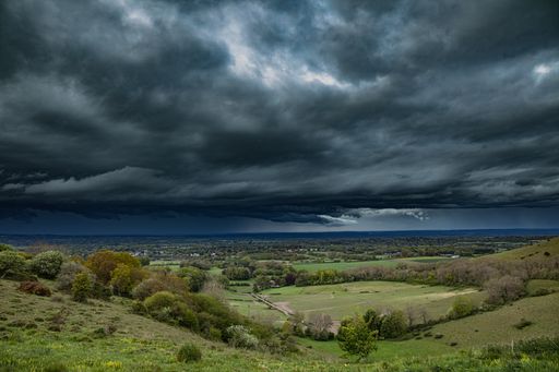 A dramatic cloudy sunset sky over a rural landscape