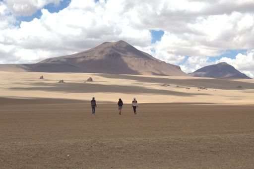 A group of people standing in the sand dunes of Bolivia