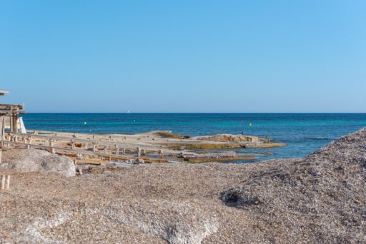 A rocky side of Migjorn beach on a sunny day in Formentera, Spain