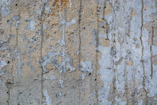 A closeup shot of a damaged grungy marble wall with oil paint leftovers