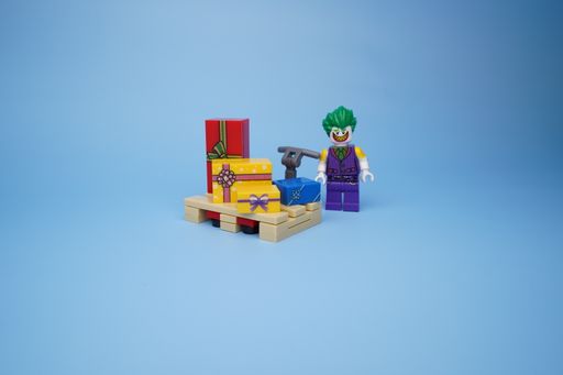 A Lego Joker isolated against an empty blue background
