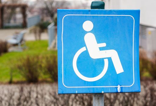 A closeup shot of a blue sign with a wheelchair symbol