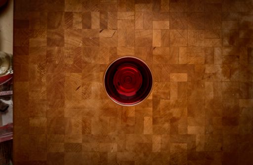 A top view of a glass of red wine on a rustic wooden table