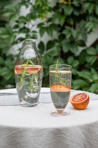 A bottle and glass with grapefruit slices and a plant
