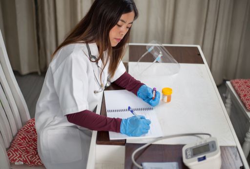A shot of a southeast Asian girl working in a laboratory and writing about her test findings.