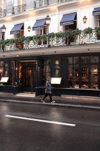 A man strolling on a Parisian sidewalk