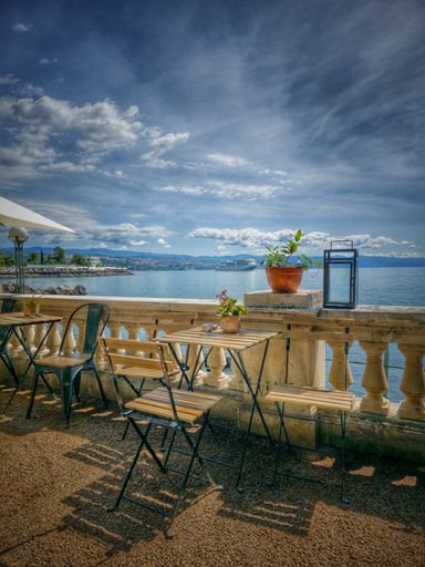 The tables on a balcony with sea and mountain views in the background in Croatia, Opatija