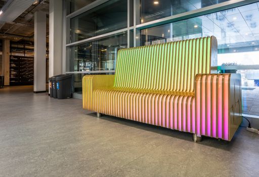 A big cool wooden bench with lights and waste beans on the left