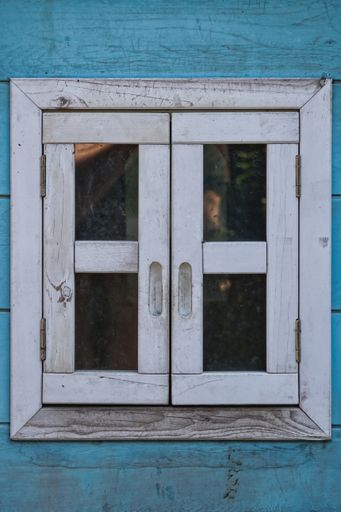A closeup shot of a blue and white wooden window