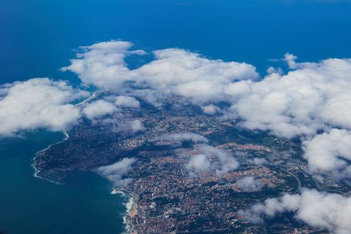 An aerial view of clouds in the blue sky over the coastline