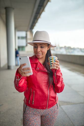 A Spanish woman in a red jacket in the street taking a selfie