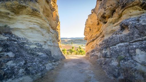 Thin rock formations nestled between two larger rocks, casting shadows on each other