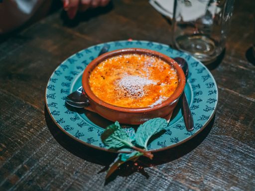 A closeup shot of a creme brulee dessert in green plate