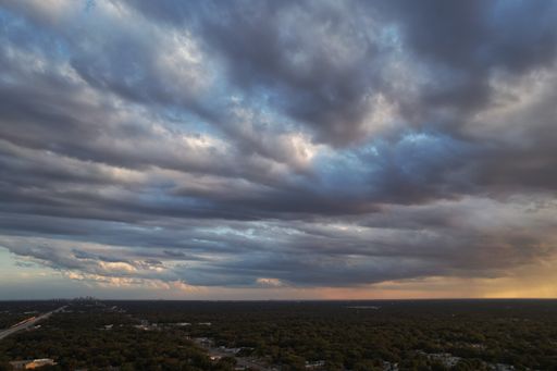 cloudy day during summer with the city on background and sunset on right side