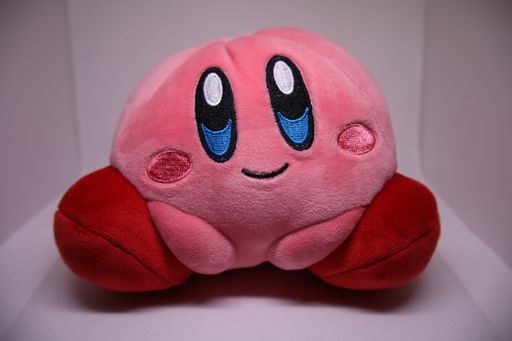A closeup shot of a cute pink Pokemon Kirby stuffed toy