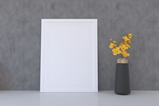 A frame with a blank canvas and a vase with flowers