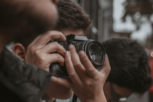 A closeup shot of a man in a crowd taking photos