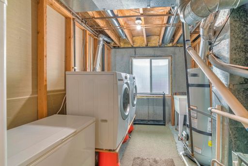 a laundry room with two washing machines and wooden ceiling