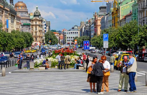 The tourists walking through Wenceslas Square in Prague and enjoying a beautiful street view