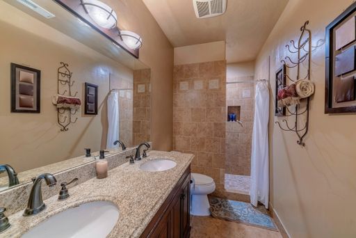 A modern bathroom with two sinks and a shower cabin