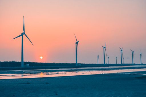 The wind turbines in a field at sunset, renewable energy source landscape