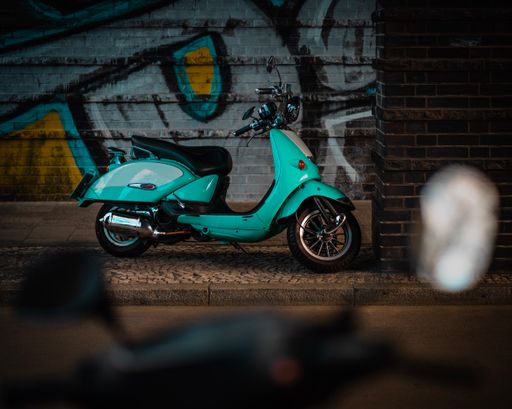 Motorcycle parked near dark brick wall at night