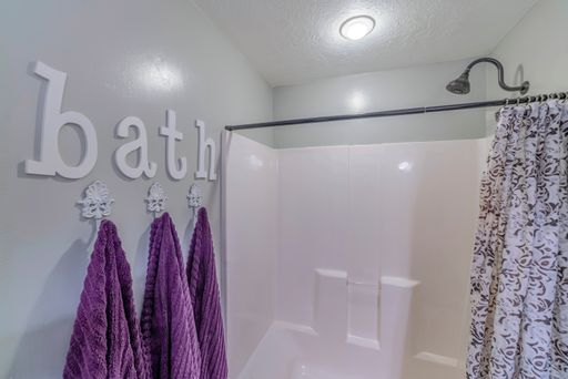A bath with a curtain in a bathroom with the word bath on the wall