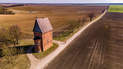 Historic red brick church by rural road