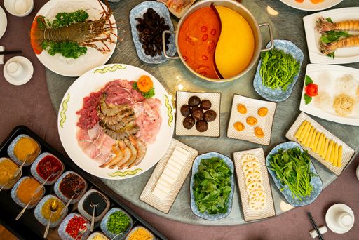 A high angle shot of dishes with spices and sauces on an oriental round table