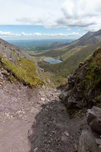A vertical shot of high mountains and a small lake in Killarney National Park, Ireland