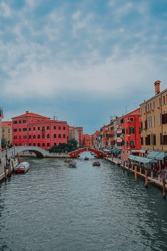 A beautiful view of a Venetian street with a grand canal and bridge over it