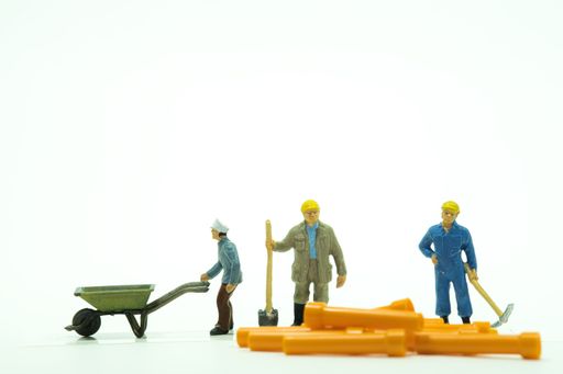 A closeup shot of small figure toys of workers on an isolated background