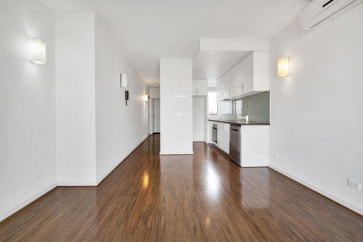 An empty kitchen room with laminate flooring and white walls