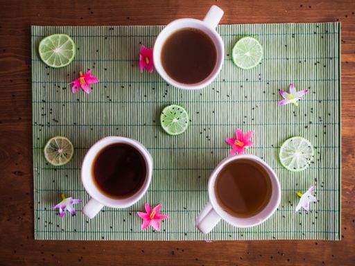 A high angle shot three different shades of hot tea in a white mug placed on the table