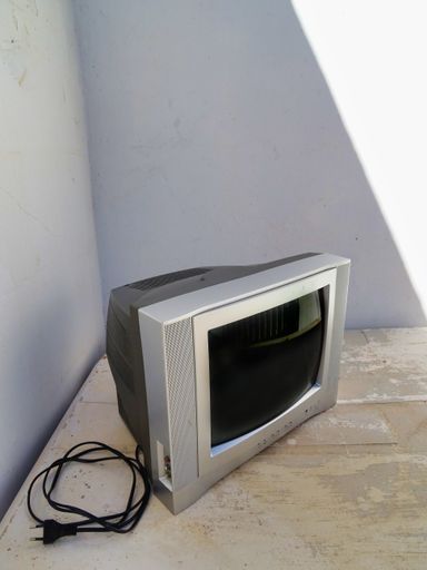 A small TV set on the floor against a wall